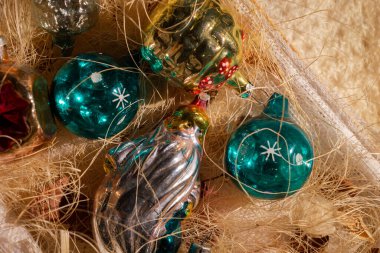 Christmas tree glass toys from the USSR in a box. Old colorful Christmas balls and a shiny figure of Santa Claus.