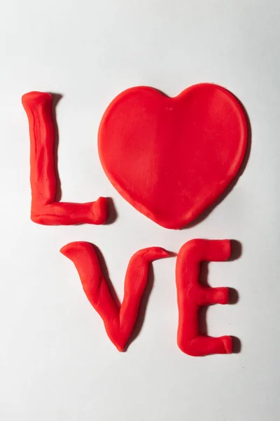 Word Love Made Red Plasticine White Background Vertical Photo Valentine — Stock Photo, Image