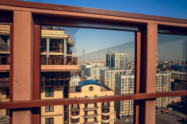 Terastan şehir sokaklarına, evlere, mavi gökyüzüne bak. Güneşli bir bahar günü.