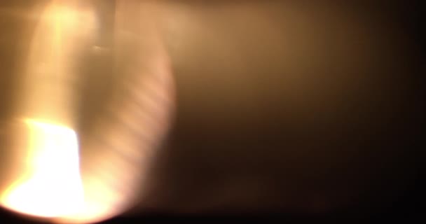黒い背景に薄暗い光が漏れます。ボケ効果のあるレンズフレアバーストオーバーレイ. — ストック動画