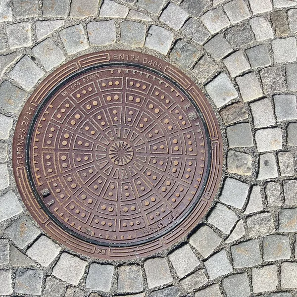 Overhead shot of the metal cover of a sewer in Lillehamer. — Stock Photo, Image