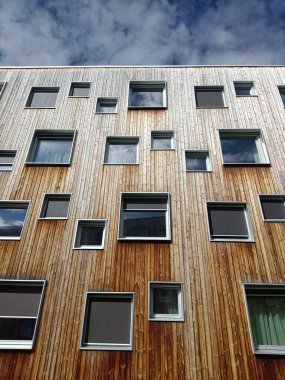 Pencereli, modern bir ahşap binanın ön cephesinin yan görüntüsü..