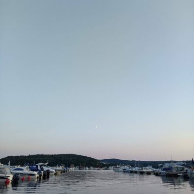 Finlandiya 'nın arka planında ay olan bir tekne iskelesi manzarası.