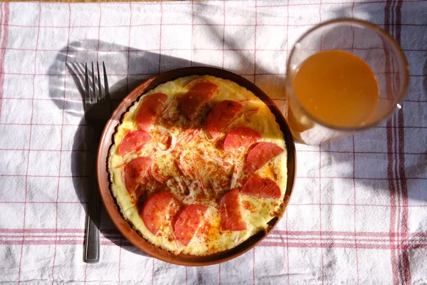 Kahvaltıda domatesli omlet ve kil tabakta kırmızı biber.