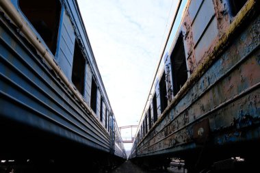 Trenin eski mavi Ukraynalı vagonu. Saçları örülü, camları hasarlı ve boyalı insanlar..