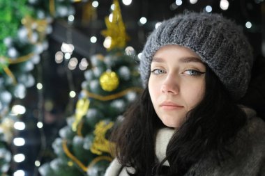 Gülümseyen kızın güzel mutlu yüzü. Arka planda Noel. Işıklı mutlu yıllar.