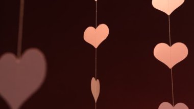 Kırmızı arka planda uçan kırmızı kağıt kalpler. Aşkın sembolü. Güzel uçan pembe kalpler. Sevgililer Günün kutlu olsun..