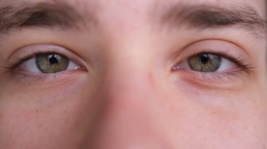 Close up of Man's face. Attractive boy with his beautiful green eyes. European young male model looking at camera.extreme close-up,