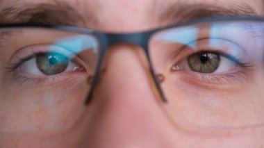 Gözlüklü adamın yüzünü kapat. Çocuk güzel yeşil gözlerini açıyor. Kameraya bakan yeşil gözlü Avrupalı genç erkek model. aşırı yakın çekim, 