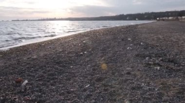 Environmental pollution on the beach near railway. Spilled garbage on the beach of the big city, Mariupol, Ukraine. Environmental pollution. Ecological problem.