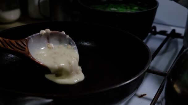 Een pan vullen met pannenkoekendeeg. Koken op een gasfornuis. Pannenkoeken met gaten. Pannenkoekenweek. Russische traditie. — Stockvideo