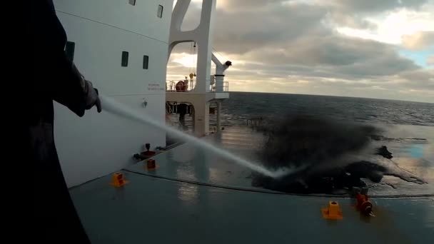 바다 속에 있는 화물선의 갑판 덮개를 검은 금속 광석인 자기 (磁 티트 ) 에서 씻는 뱃사람들 — 비디오