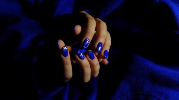 Mani delle donne con manicure blu su sfondo blu strutturato — Video Stock