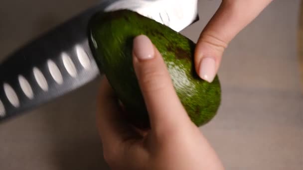 Las manos femeninas cortan el aguacate por la mitad. Aguacate fresco maduro, Desayuno saludable, Comida vegetariana — Vídeos de Stock