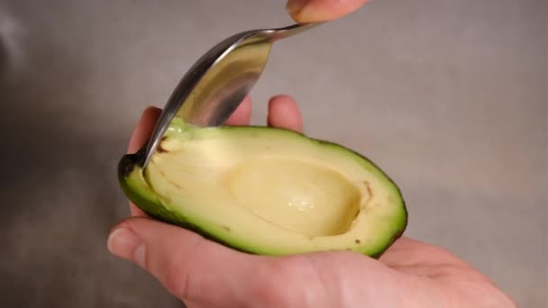 Mužské ruce oloupají avokádo vejpůl. Čerstvé zralé avokádo, Zdravá snídaně, Vegetariánské jídlo — Stock video
