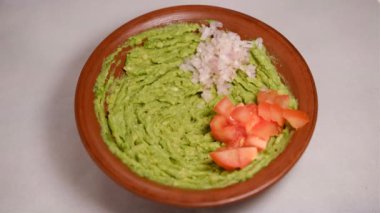 Avokado ezme dönüşünün üst görüntüsü aşırı yakın çekim. Geleneksel lezzetli soslu guacamole. Kağıt saniye ekleniyor