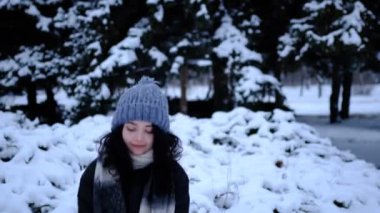 Karlı ormanda bir kadın ve bir avuç kar. Neşeli kız güzel kış gününün tadını çıkarıyor. Kış zamanı