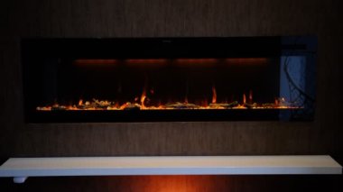 Elektrikli şömine, yapay parlayan alev, iç dekorasyon, turuncu arka ışıklandırmalı kristallerde turuncu alev..