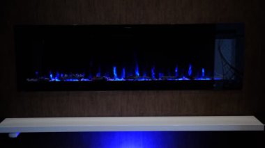 Elektrikli şömine üzerinde yapay parlayan alev, iç dekorasyon, kristallerde mavi alev.