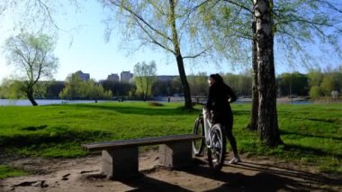 a bicycle with a woman in the sunset overlooking the lake, river. Making photos on smartphone