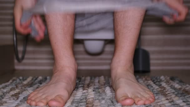男人坐在厕所里 腹泻的概念 一条灰色内裤的男人的毛腿在动 — 图库视频影像