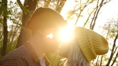 Güzel, genç bir çift karşı günbatımı ışık seyahat onların zaman öpmek için bekleyen portresi kapatın.