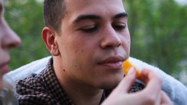 Kadın, orman kampında bir adamı oralet huzuruyla besler. Açık havada aşk hikayesi