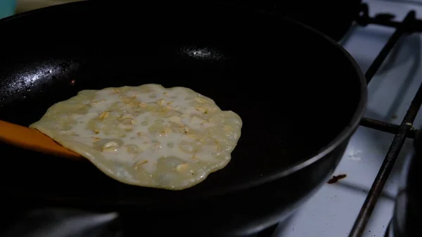Turning a pancake in a pan. Big round pancake Cooking on gas-cooker. Cooking smoke goes up from pancake. Pancakes with kefir. Pancakes with holes. Pancake week. Russian tradition. 4K 400mb s