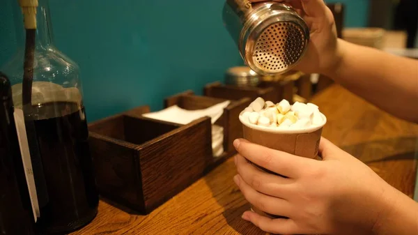 El, kahve kapuçino baharatları, tarçın ve çikolata serpiyor. Renkli görüntü. Yaşam tarzını kabul et. Fast food self servis.