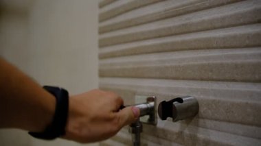 A man's hand takes a hygienic shower for washing and care of intimate places, bidet. Close-up.