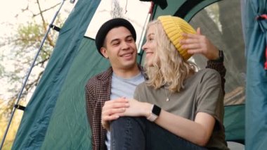 Slow motion Young couple relaxing in camping tent during summer weekend. guy and girl enjoying natural landscape. Friends spending time together outdoor