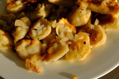 Homemade potato dumplings or vereniki pierogi, served with fried onions. Rustic style, comfort eastern europe cuisine.