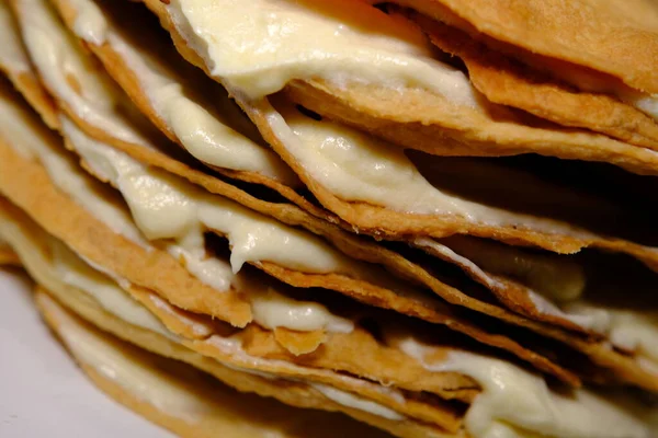 Puff pastry cake Napoleon layers closeup texture with white cream inside.