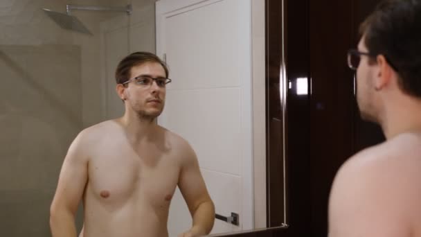 Young Man Glasses Examining His Face While Watching Mirror — Stockvideo