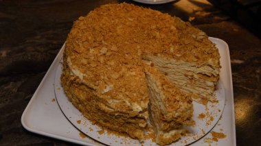 man's hands take a piece of cake Napoleon with the inscription Love. Delicious homemade holiday cake. Top view. Close-up