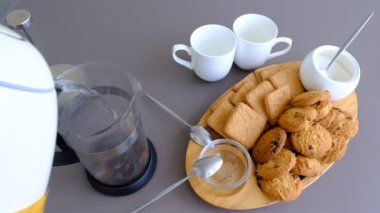 Pour hot water, boiling water into a transparent glass teapot. Brew collection of tea leaves, blackberries, blueberries, cranberries, herbs. Home tea. The process of brewing tea. Black tea with natural leafs.