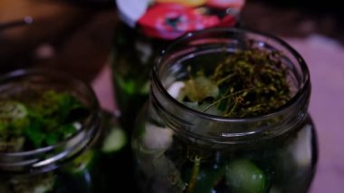 Pouring hot water on dill with cucumbers for steeping.