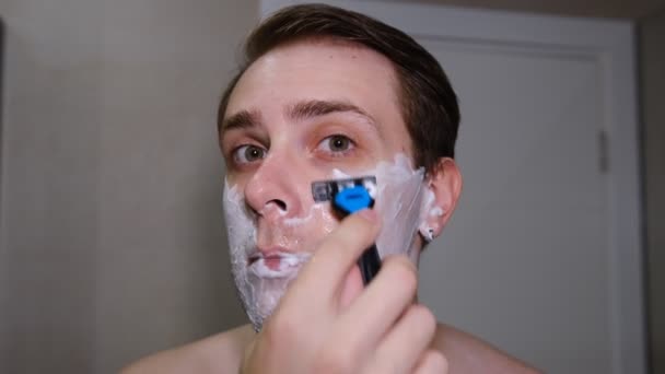 Serious Young Guy Shaving His Beard Bathroom Razer — Vídeo de Stock