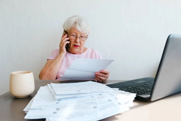 Senior Woman Holding Papers Busy Laptop Managing House Utility Bills Imagem De Stock