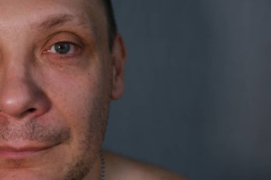 Middle-aged man face fragment, half man face, close up portrait of a middle aged man on grey background.