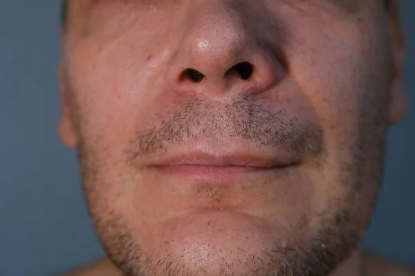 Middle-aged man face fragment, half man face, close up portrait of a middle aged man on grey background