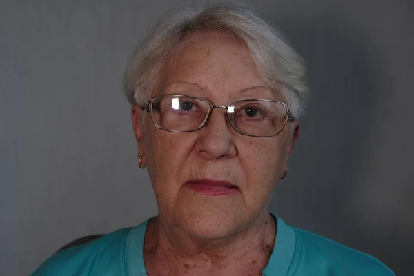 Close up portrait of senior woman with gray eye's looking at the camera in glasses