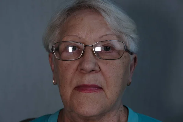 Close up portrait of senior woman with gray eye\'s looking at the camera in glasses