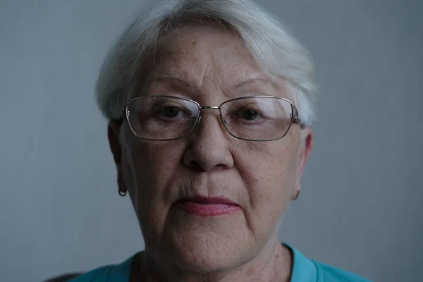 Close up portrait of senior woman with gray eye\'s looking at the camera in glasses