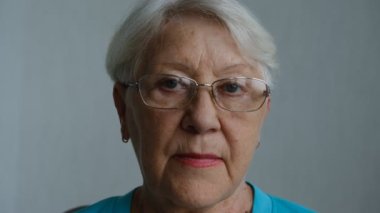 Close up portrait of senior woman with gray eye's looking at the camera in glasses