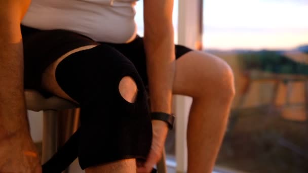Close Knee Support Brace Leg Man Sunset Lights Window Massage — Vídeos de Stock