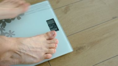 Man stand on the digital weight scale. Diet, weight loss, overweight, obesity and health concept. Man checking the weight.