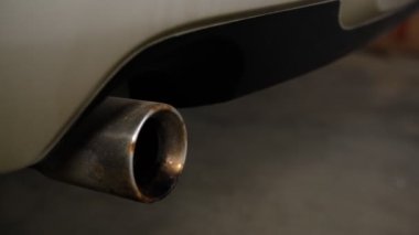 Arabanın egzoz borusunu motorun başından itibaren titreşimle yakın çekim yap..