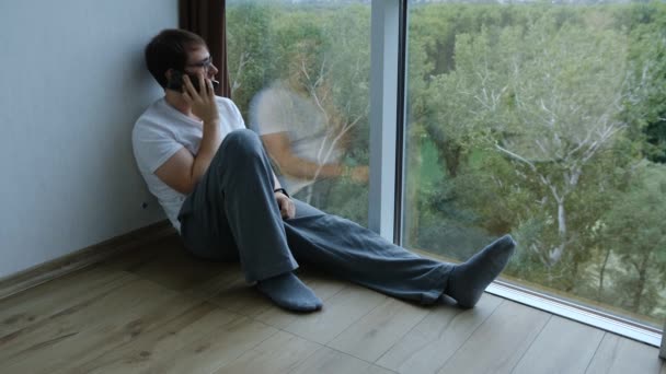 Beau Jeune Homme Est Assis Sur Sol Avec Téléphone Près — Video