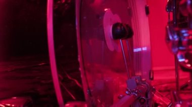 Davulcu rock konserinden önce davul fıçısında prova yapıyor. Kırmızı ışıkta stüdyoda bateri çalan adam..